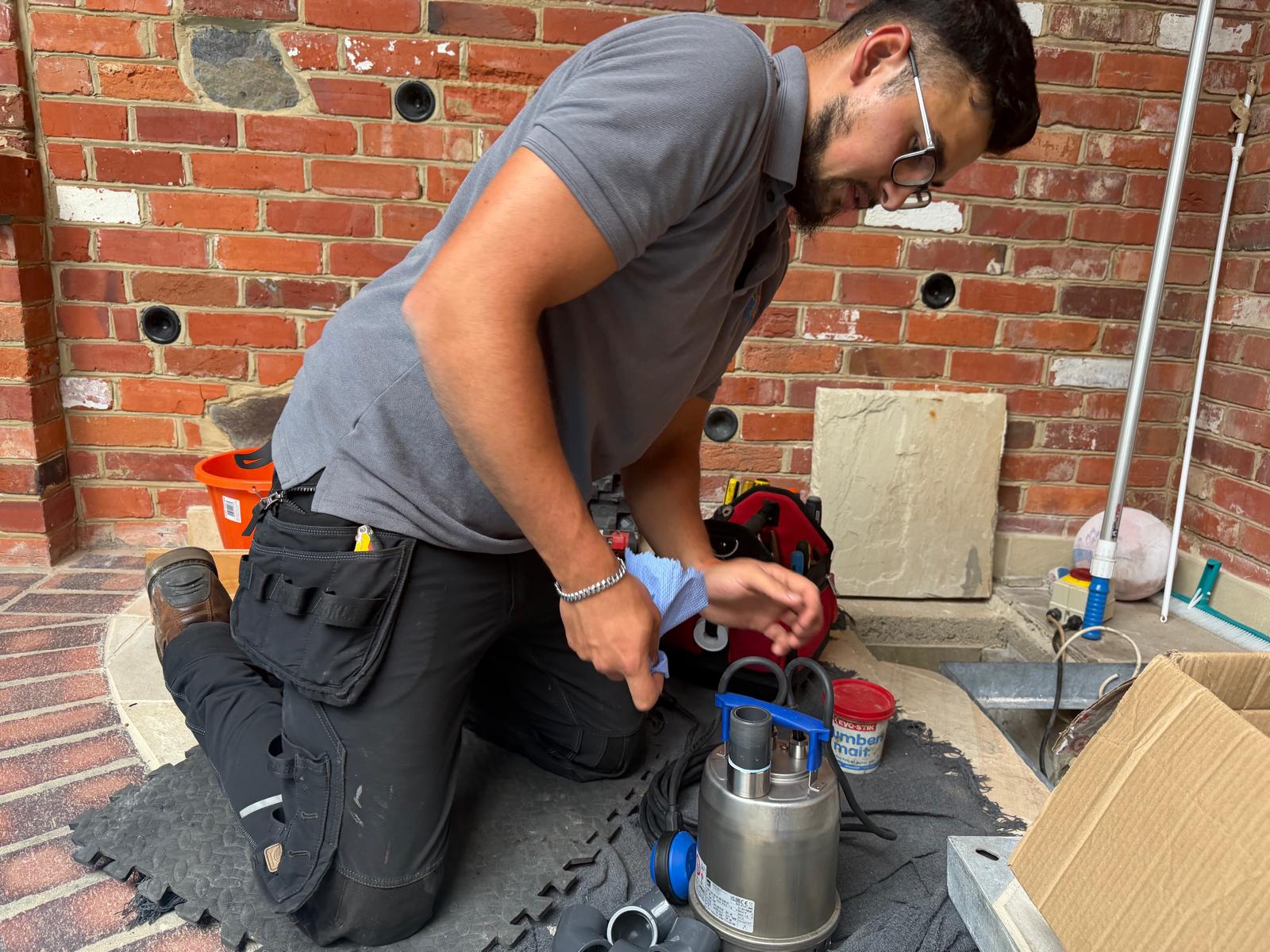 DCL technician installing basement flood prevention pump system